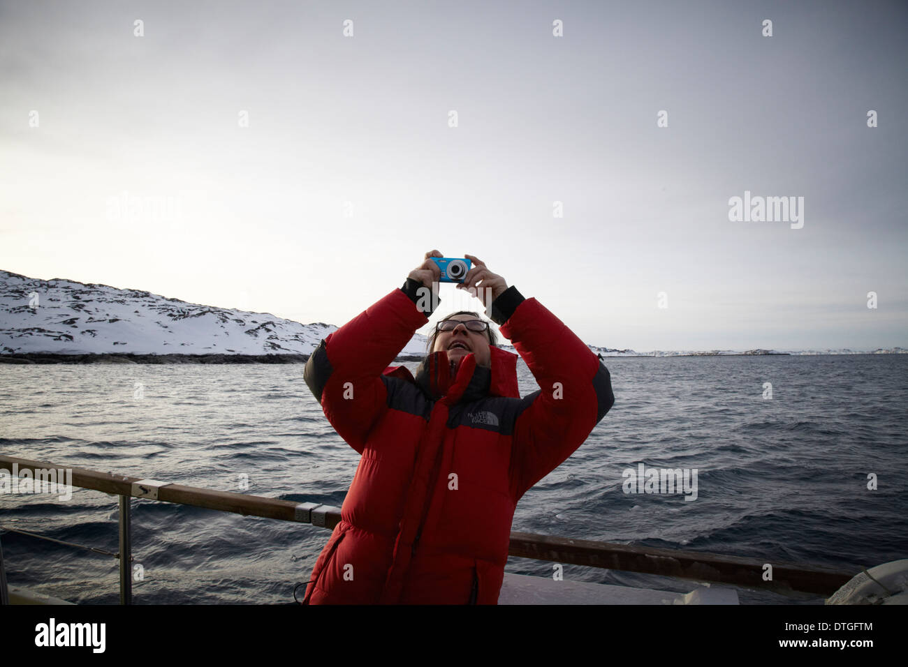 "Lächeln Sie in die Kamera". Eine grönländische Frau ein Foto des Fotografen. Stockfoto