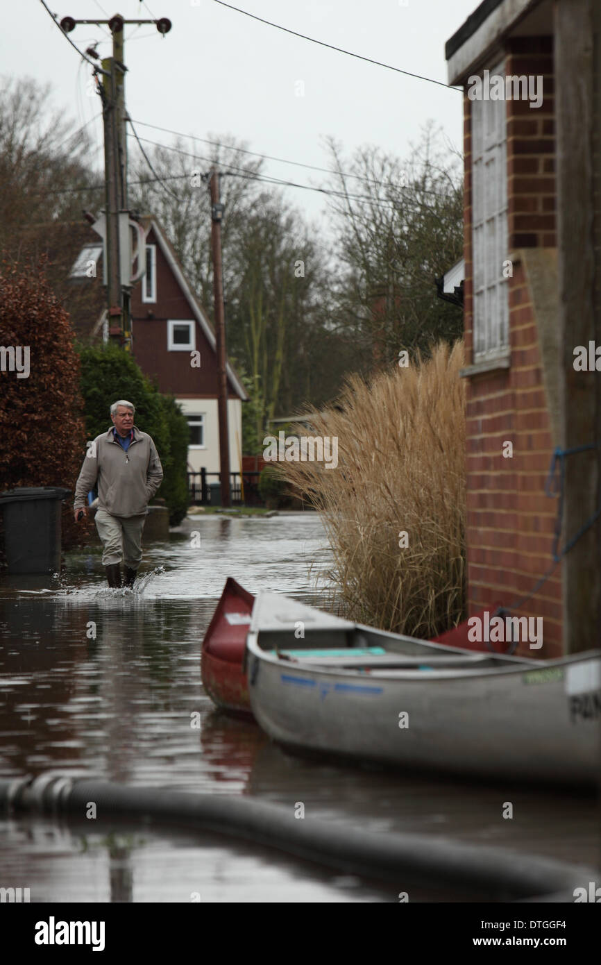 Schinken-Insel, Thames Valley, UK. Man watet, Kanu und Pumpe fließt Wasser von der Straße. Flut Wasser Surround-Häuser und Gärten. Stockfoto