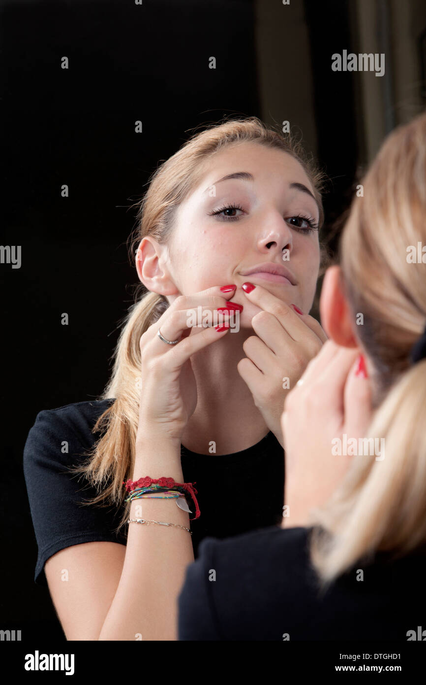 Teenager-Mädchen einen Pickel quetschen Stockfoto