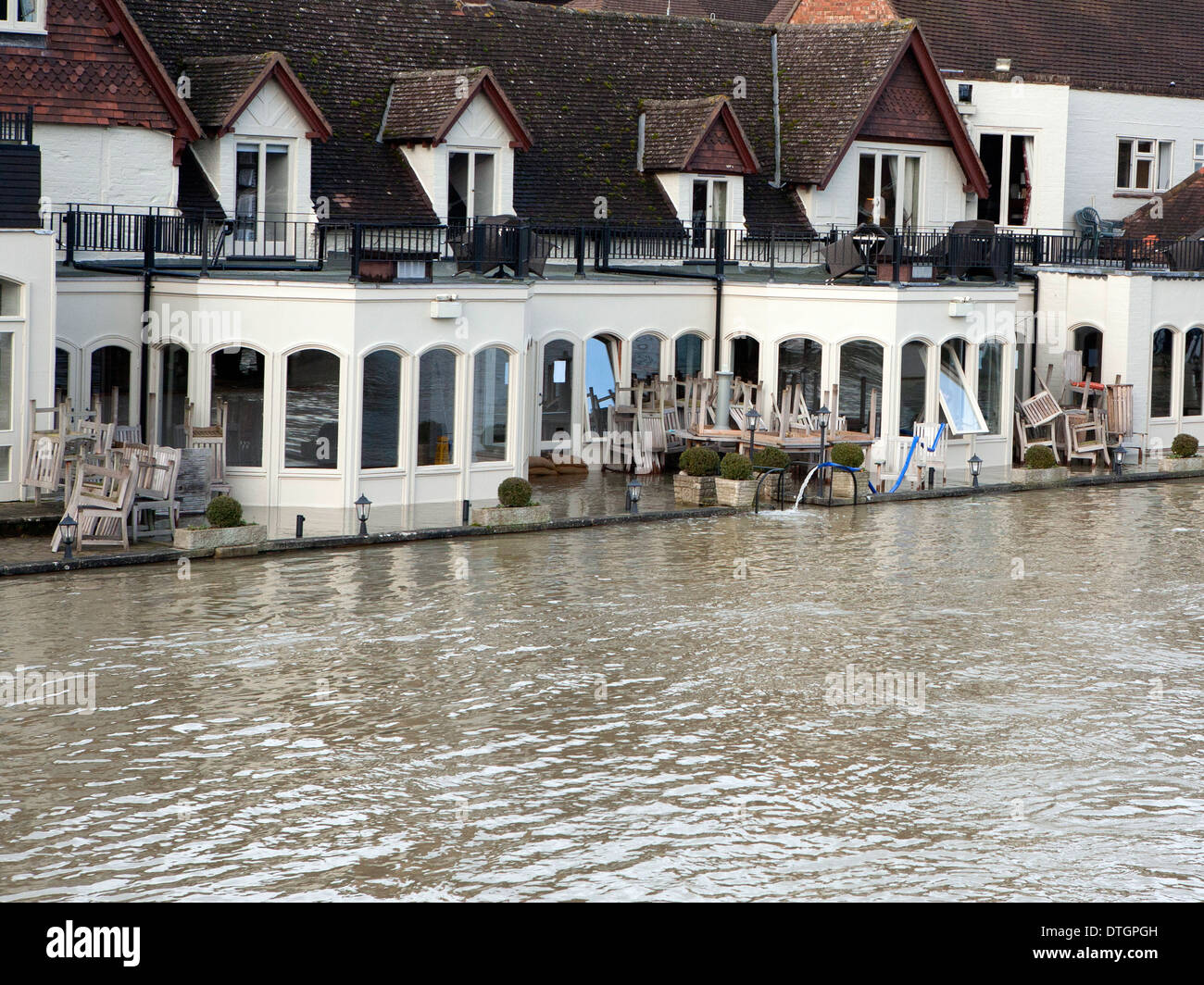 Wasser aus dem Fenster eines überfluteten Hotels am Ufer der Themse gepumpt wird. Stockfoto