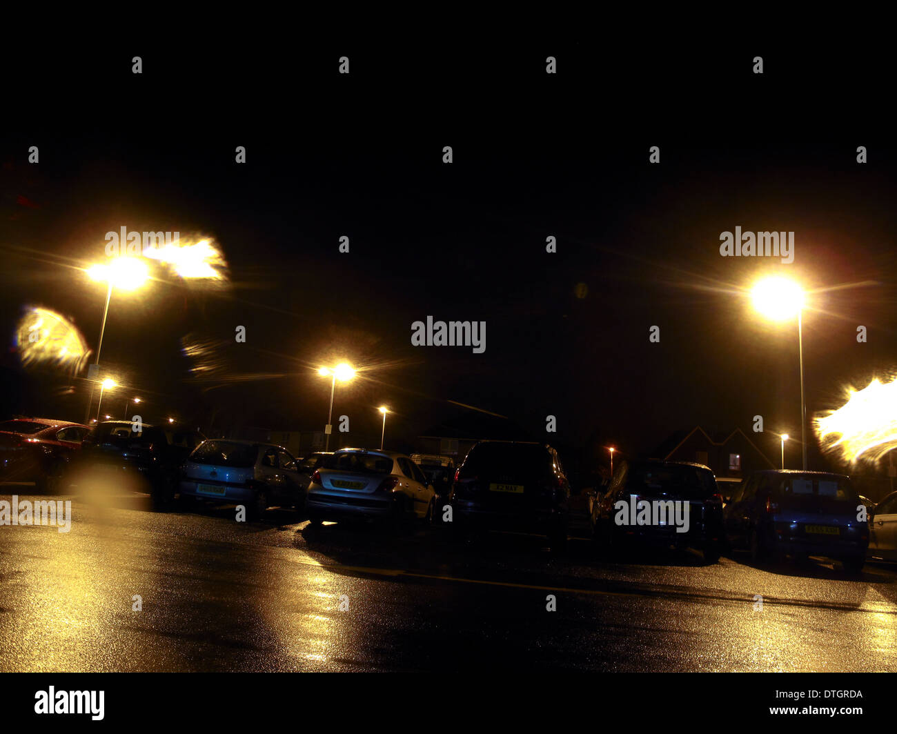 Regen durchnässt Parkplatz in der Nacht Stockfoto