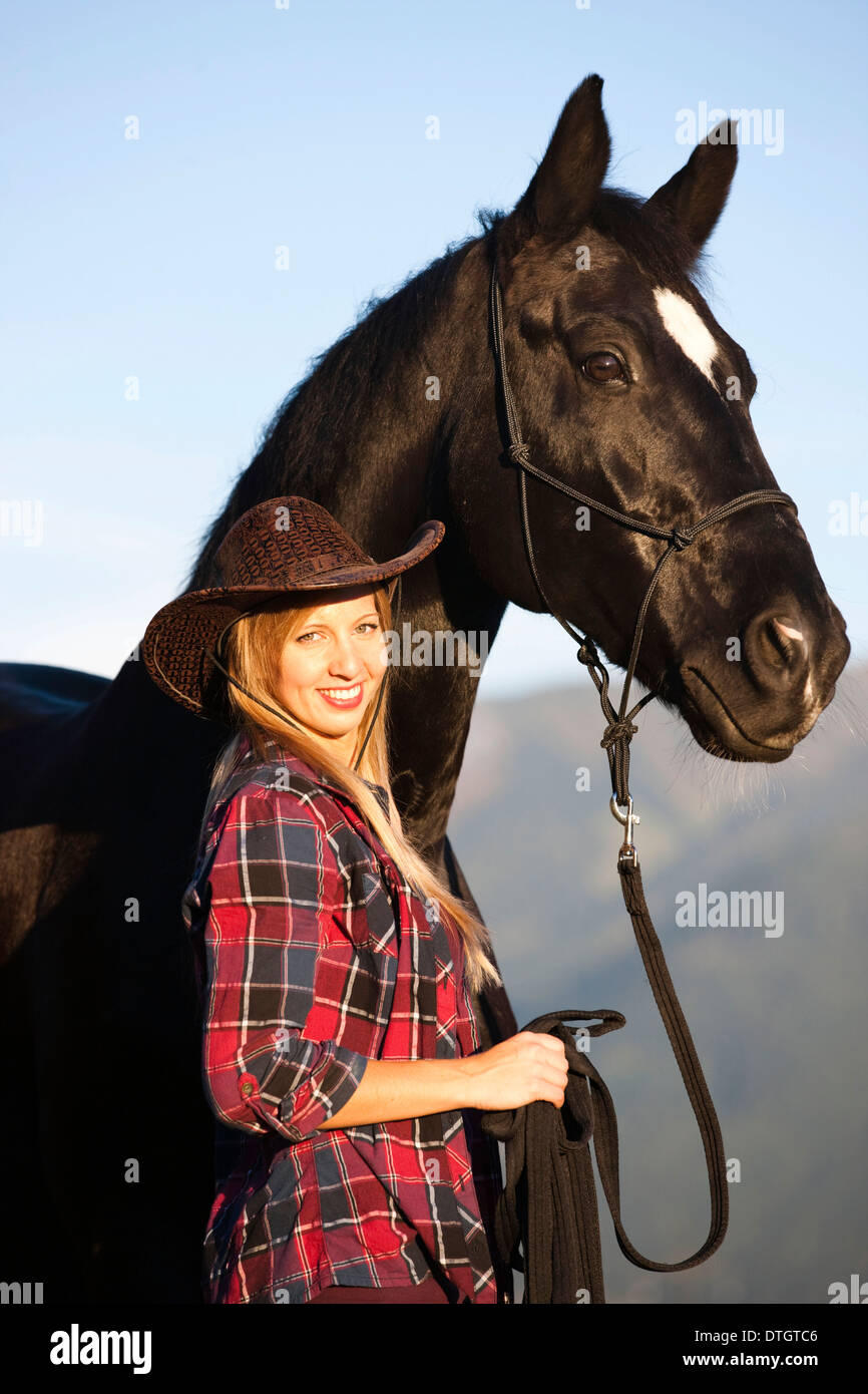 Junge Frau mit einem schwarzen Hannoveraner Pferd Nord Tirol, Österreich Stockfoto