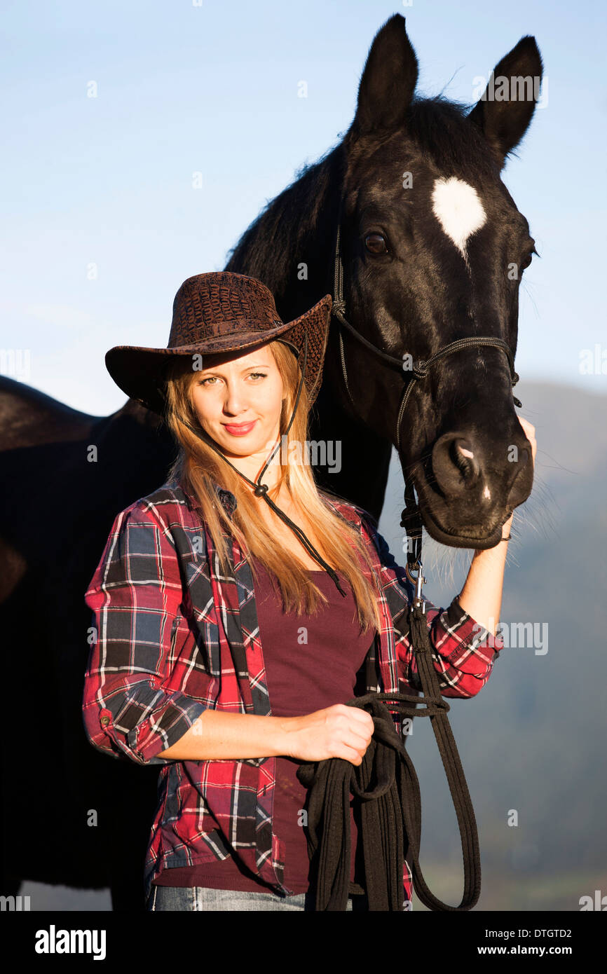 Junge Frau mit einem schwarzen Hannoveraner Pferd Nord Tirol, Österreich Stockfoto