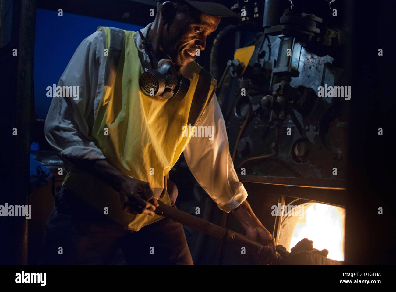 Eines der Eisenbahner der Livingstone Express Luxus Zug Kohle angetriebene Zug Lokomotive.  Der Zug stoppt. Stockfoto