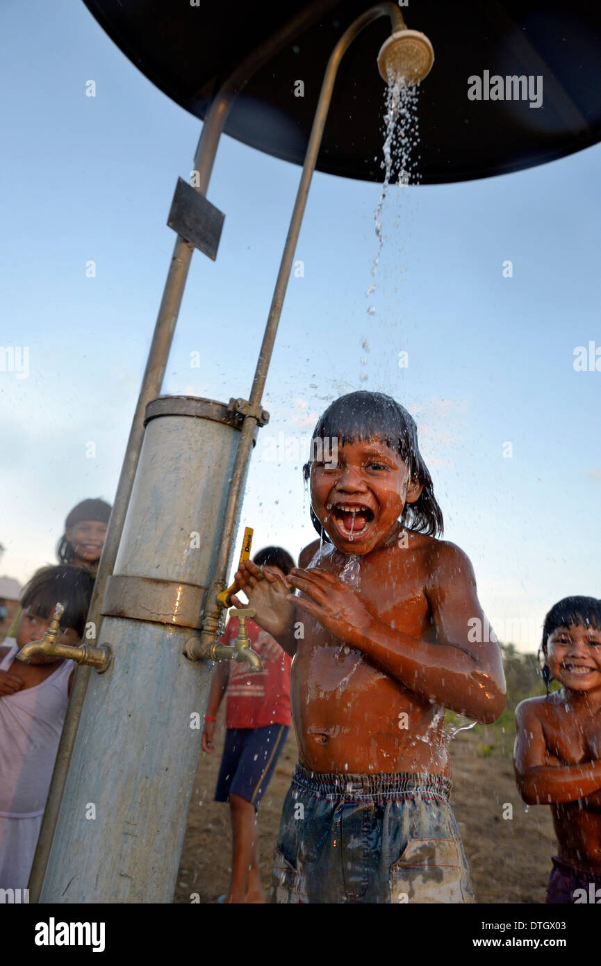 Junge der Xavantes Menschen unter der Dusche an einer Wasserstelle, installiert von Missionaren, Dorf von Ureré in der Nähe von Sangradouro Stockfoto