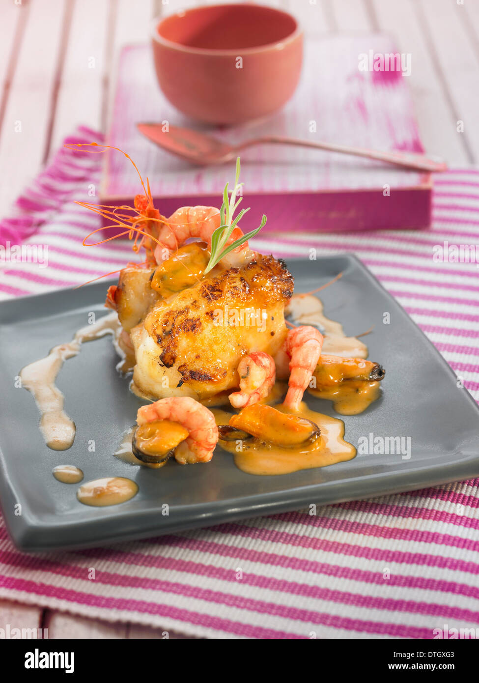 Seeteufel mit Garnelen und Muscheln, cremige Tomaten und Knoblauch-sauce Stockfoto