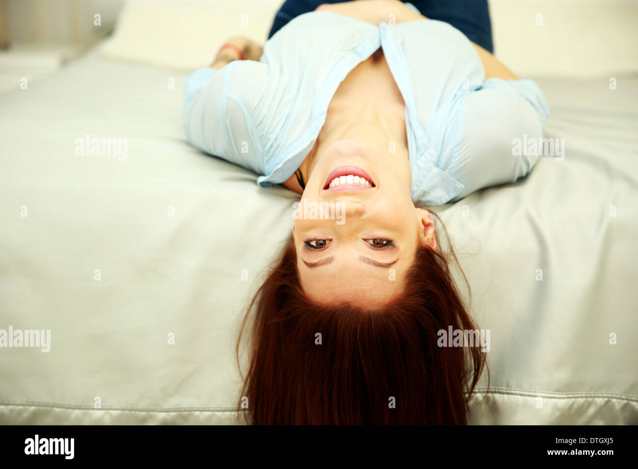 Lustige fröhliche Frau liegend auf dem Bett zu Hause Stockfoto