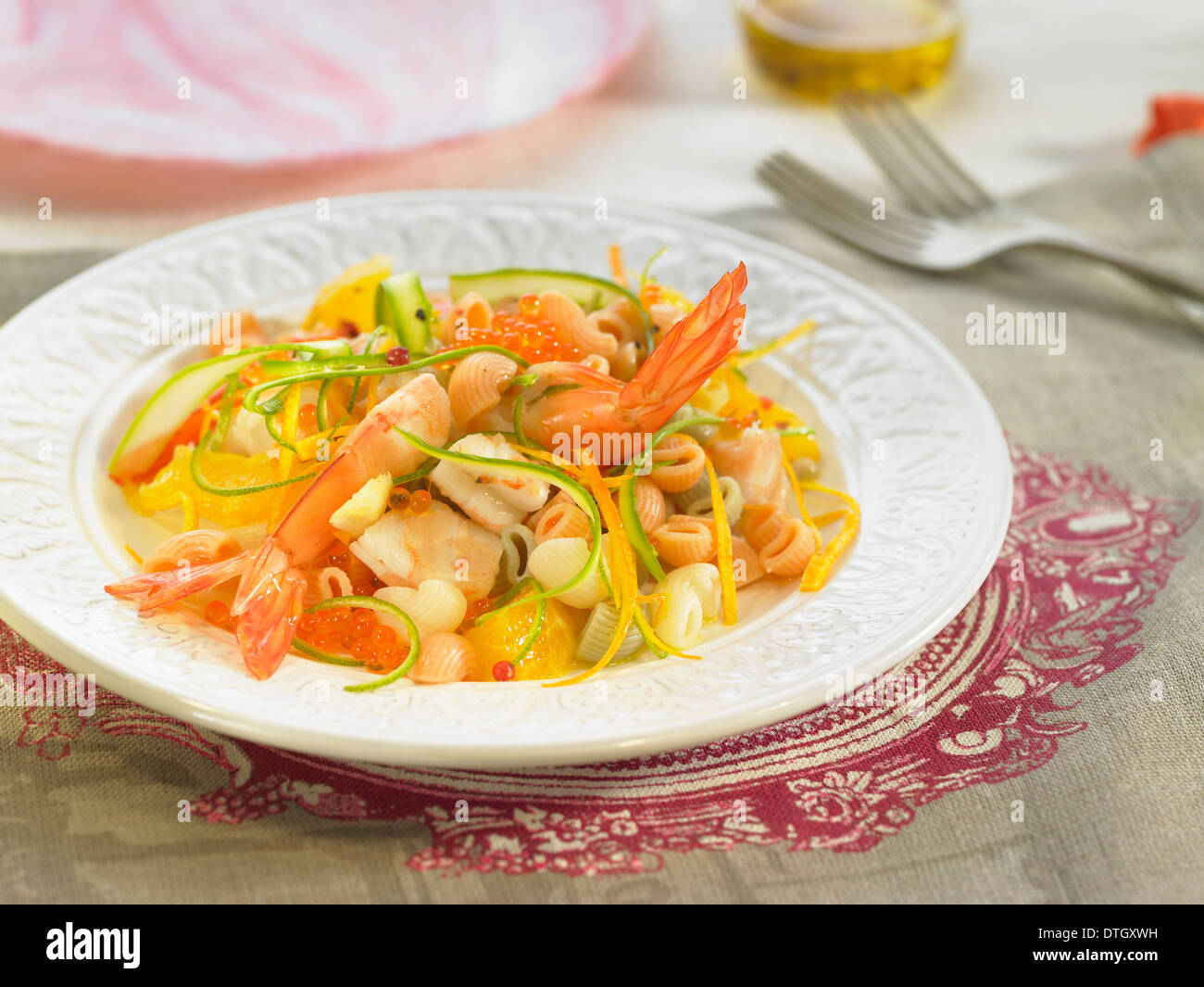 Pasta-Salat mit Shrimps, Zucchini und orange Stockfoto