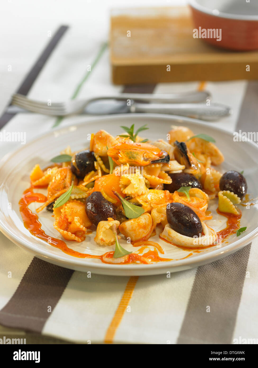 Nudelsalat mit Escabèche Muscheln, Tintenfisch, Oliven und Zwiebeln Stockfoto