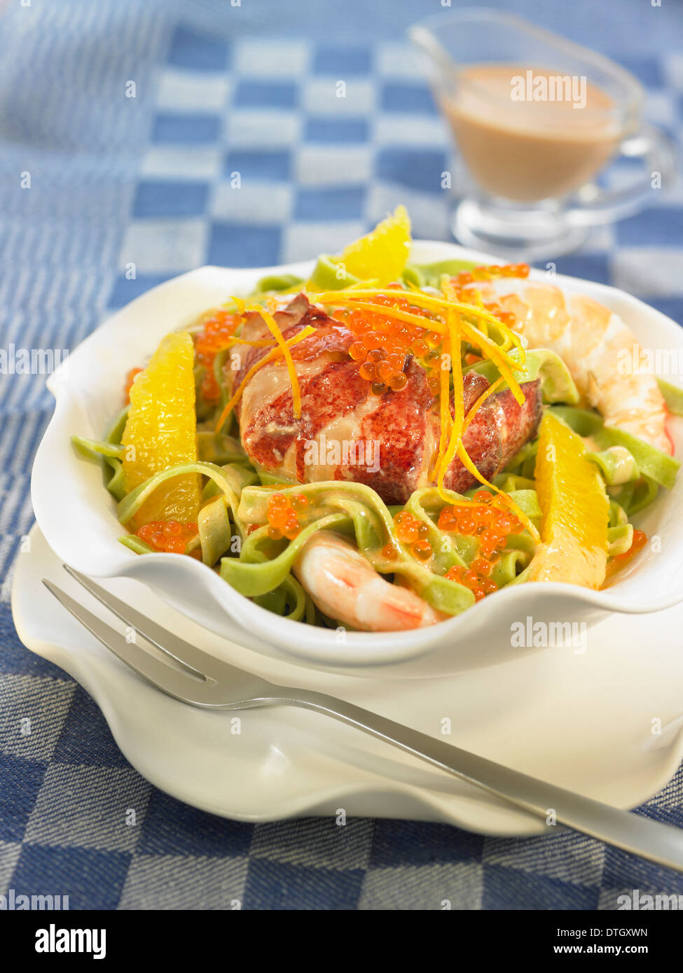 Tagliatelles Salat mit Spinat, Hummer, Garnelen und orange Stockfoto