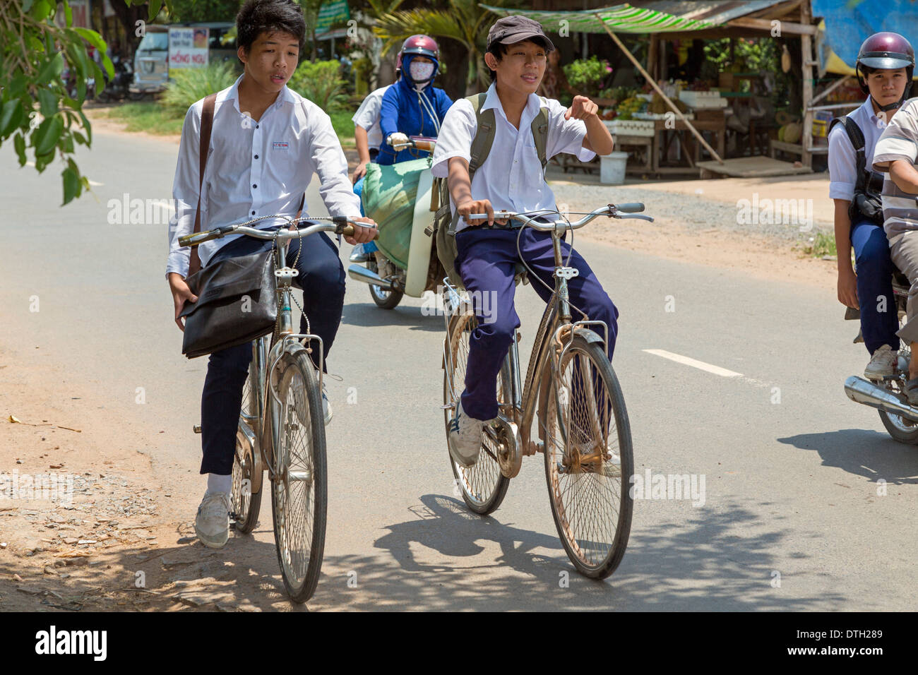 Schulkinder auf Fahrrädern im ländlichen Verkehr in Tay Ninh, Vietnam Stockfoto