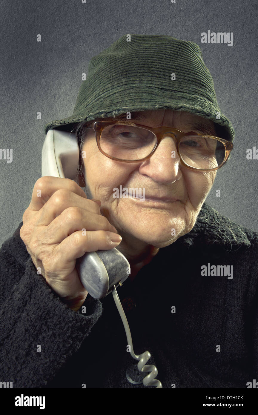 Positiven senior Frau am Telefon auf eine Vintage-Hintergrund. Stockfoto