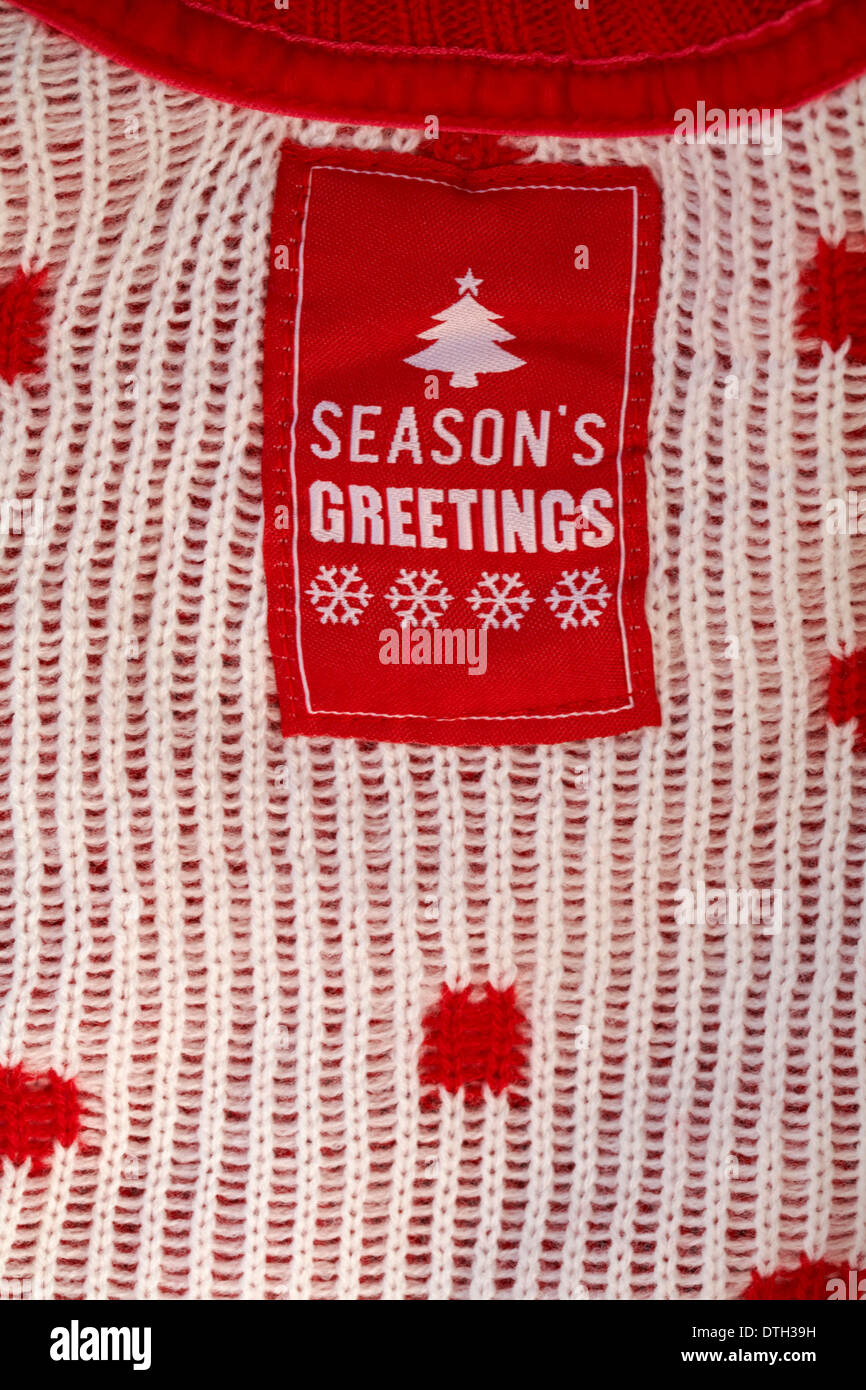 Season's Greetings Label in der Kind Winter Weihnachten jumper Bekleidung Stockfoto