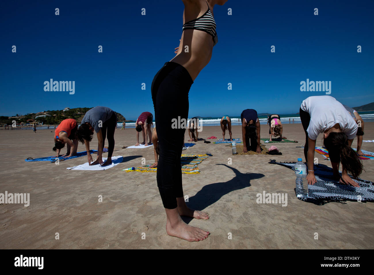 Junge Menschen Yoga zu praktizieren am Geriba Strand, Armacao de Buzios, Bundesstaat Rio De Janeiro, Brasilien. Schöne dünne Frau schlanken Bauch Stockfoto