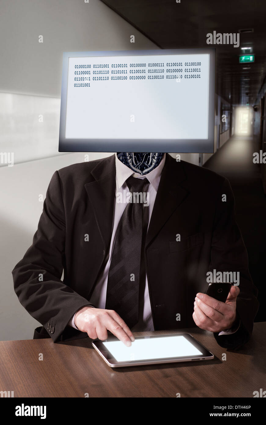 Ein Cyborg mit dem Computer-Monitor als Leiter an einem Schreibtisch sitzen. Stockfoto