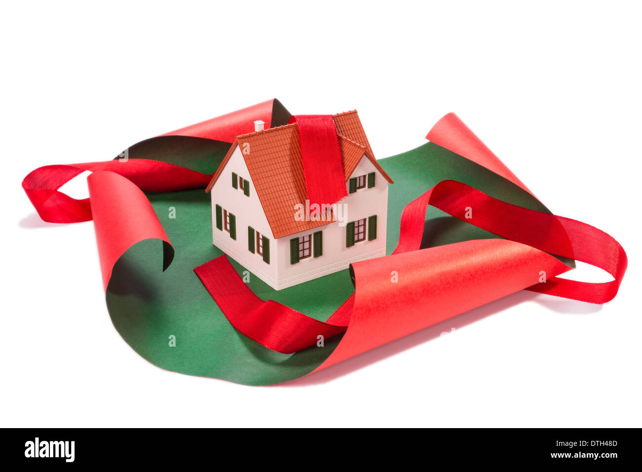 Modell eines Wohnhauses mit Geschenkpapier und Band. Stockfoto