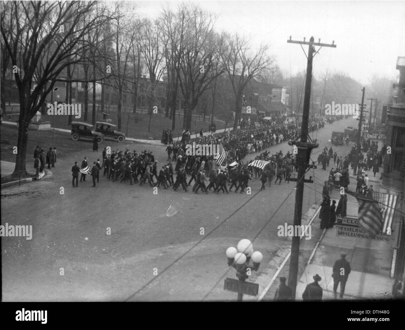 Ein historisches Bild der Prozession zum Waffenstillstand in Oxford, Ohio, 1918, mit Militärparaden, Flaggen, und Menschenmassen auf dem Marktplatz im Rahmen der Feierlichkeiten nach dem Ersten Weltkrieg. Stockfoto