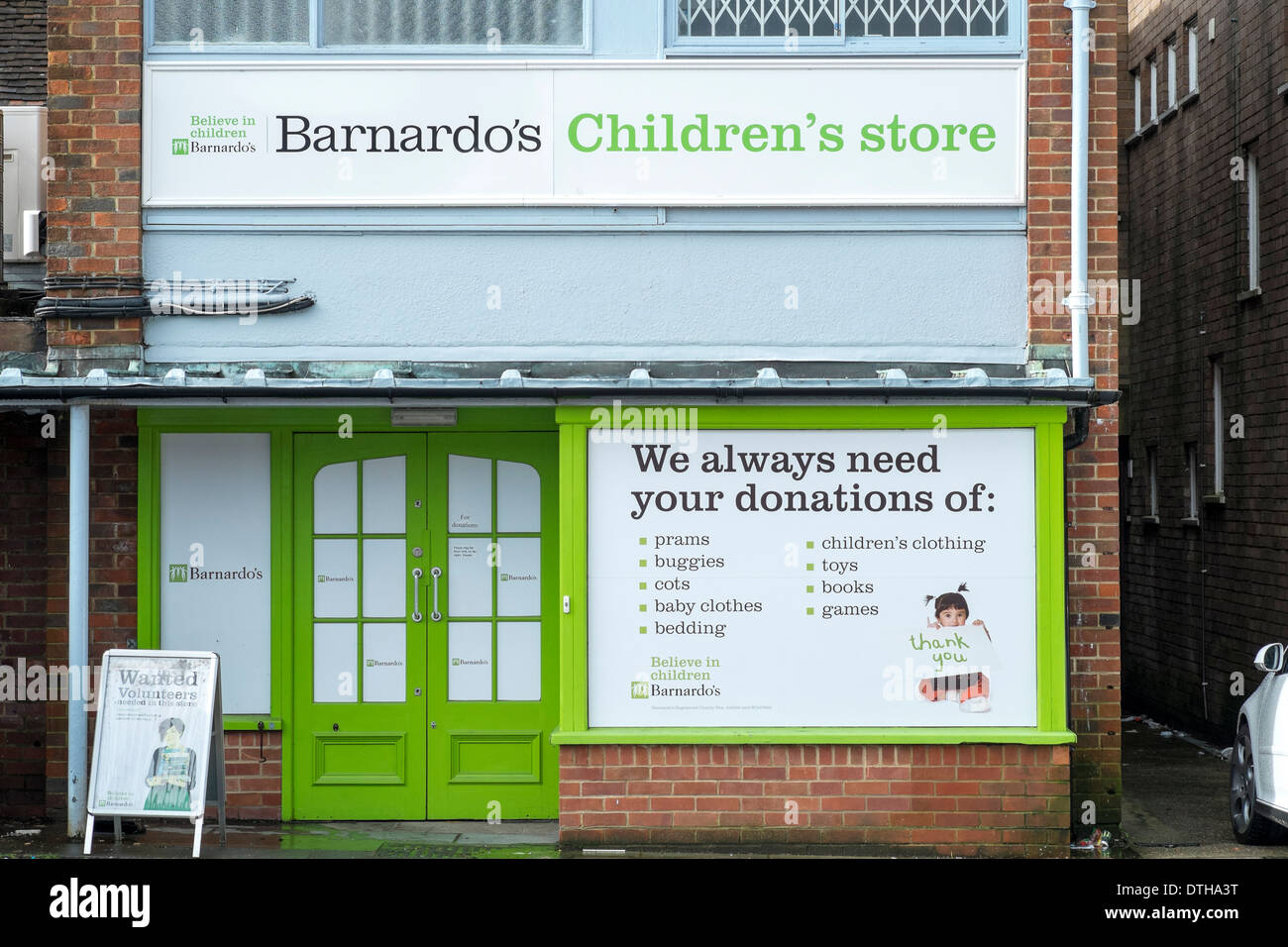 Rückseite des UK Barnardos Kinder Charity Shop mit großen Zeichen fordert Spenden von Produkten zu verkaufen Stockfoto