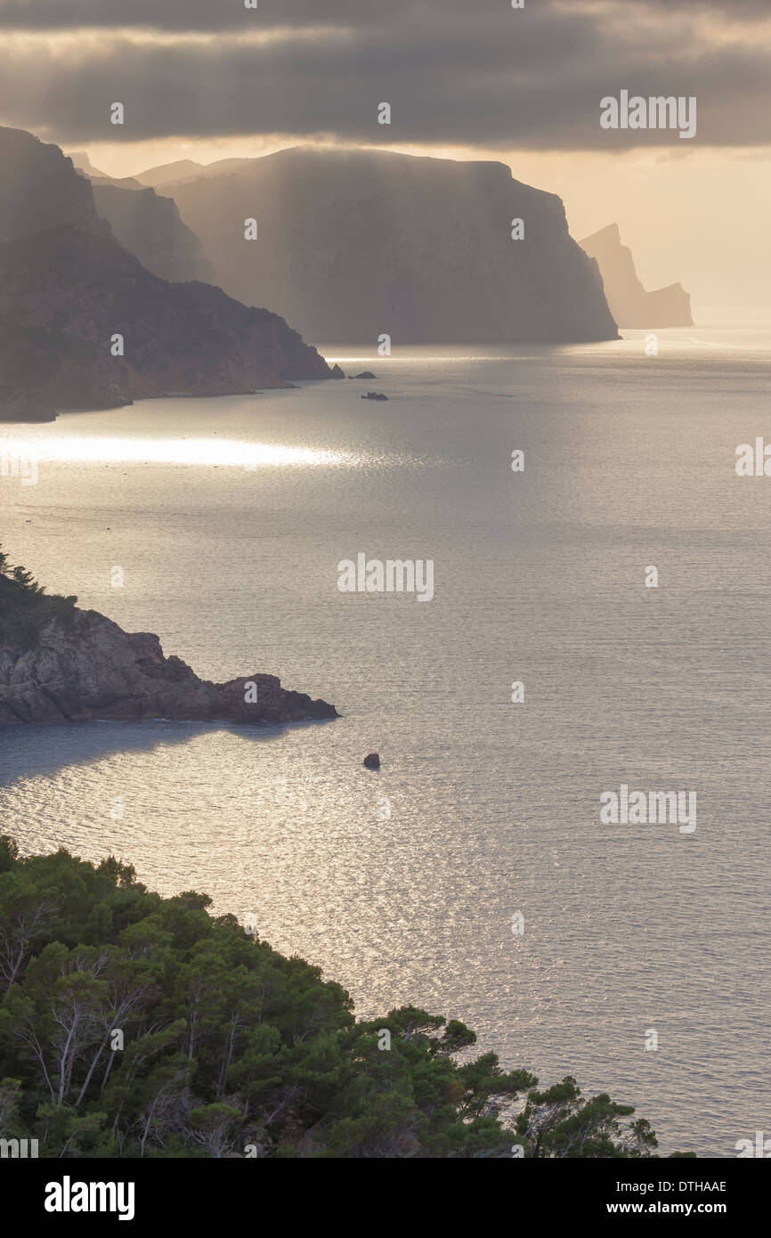 Mallorcas Nordküste. Göttliche Strahlen über Estellencs Hügel, Dragonera-Insel am Ende. Winterabend. Balearen, Spanien Stockfoto