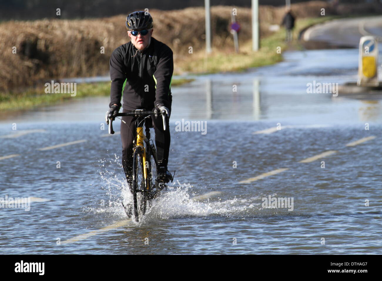 Egham, Surrey, UK. 17. Februar 2014. Flut Szenen von Egham, Surrey A Radfahrer verhandelt die zurückweichenden Fluten in Runnymede, in der Nähe von Egham, Surrey. Bildnachweis: John Maxwell-Roberts/Alamy Live-Nachrichten Stockfoto