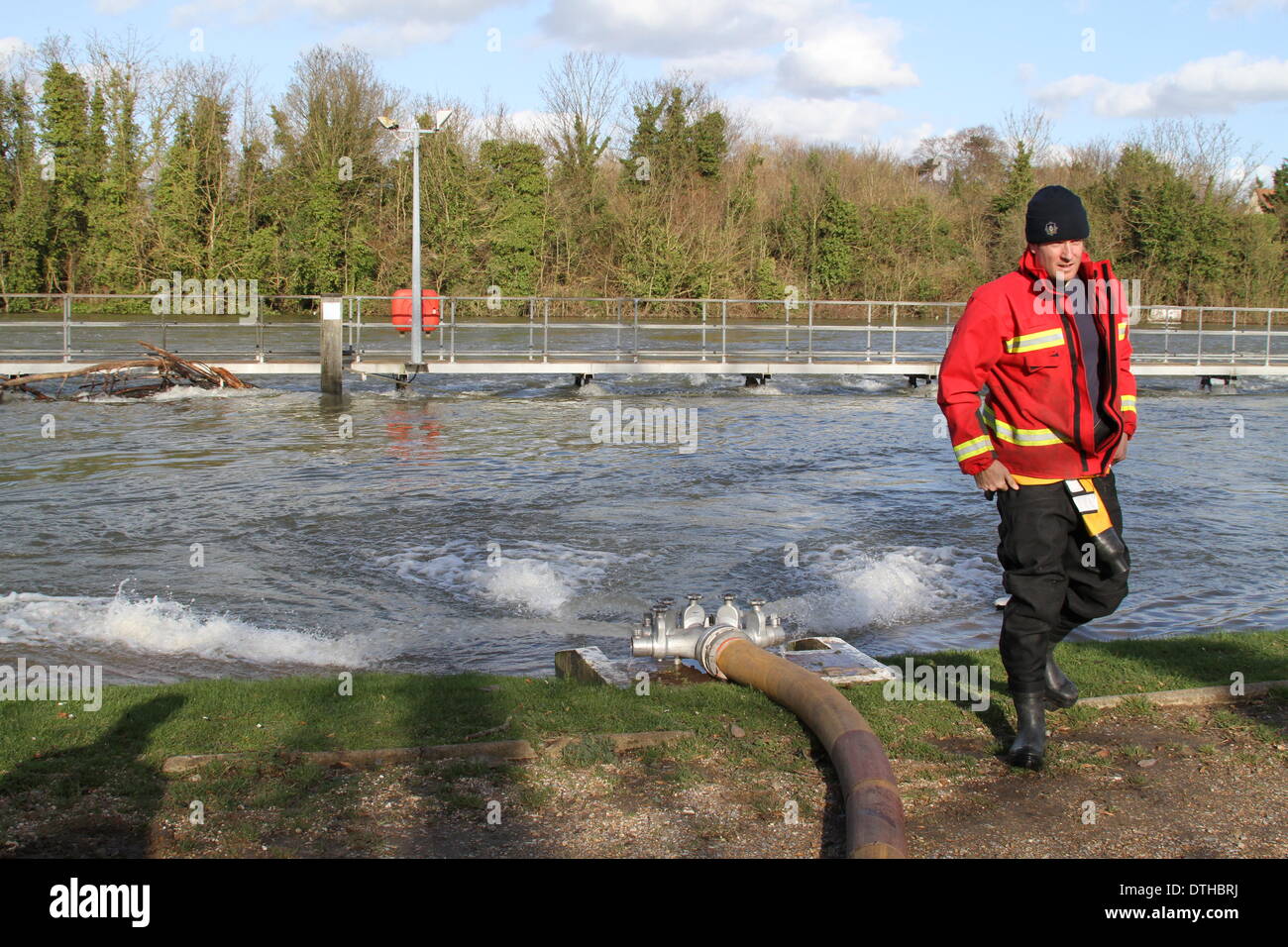 Egham, Surrey, UK. 17. Februar 2014. Flut Szenen von Egham, Surrey A West Yorkshire und Feuerwehr Feuerwehrmann Positionen einen Schlauch zum Hochwasser in der Themse bei Runnymede, in der Nähe von Egham, Surrey zu Pumpen. Bildnachweis: John Maxwell-Roberts/Alamy Live-Nachrichten Stockfoto
