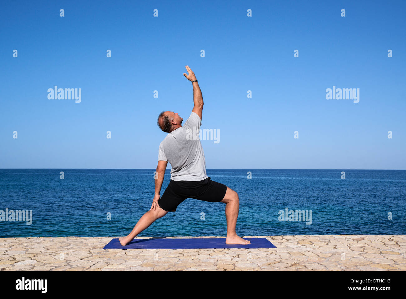 Mann-Praxis-Yoga-Meditation von einem Ozean Wasser Felsenvorsprung, Negril, Jamaika. Stockfoto
