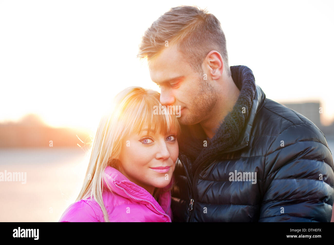 Junger Mann umarmt seine Freundin Stockfoto