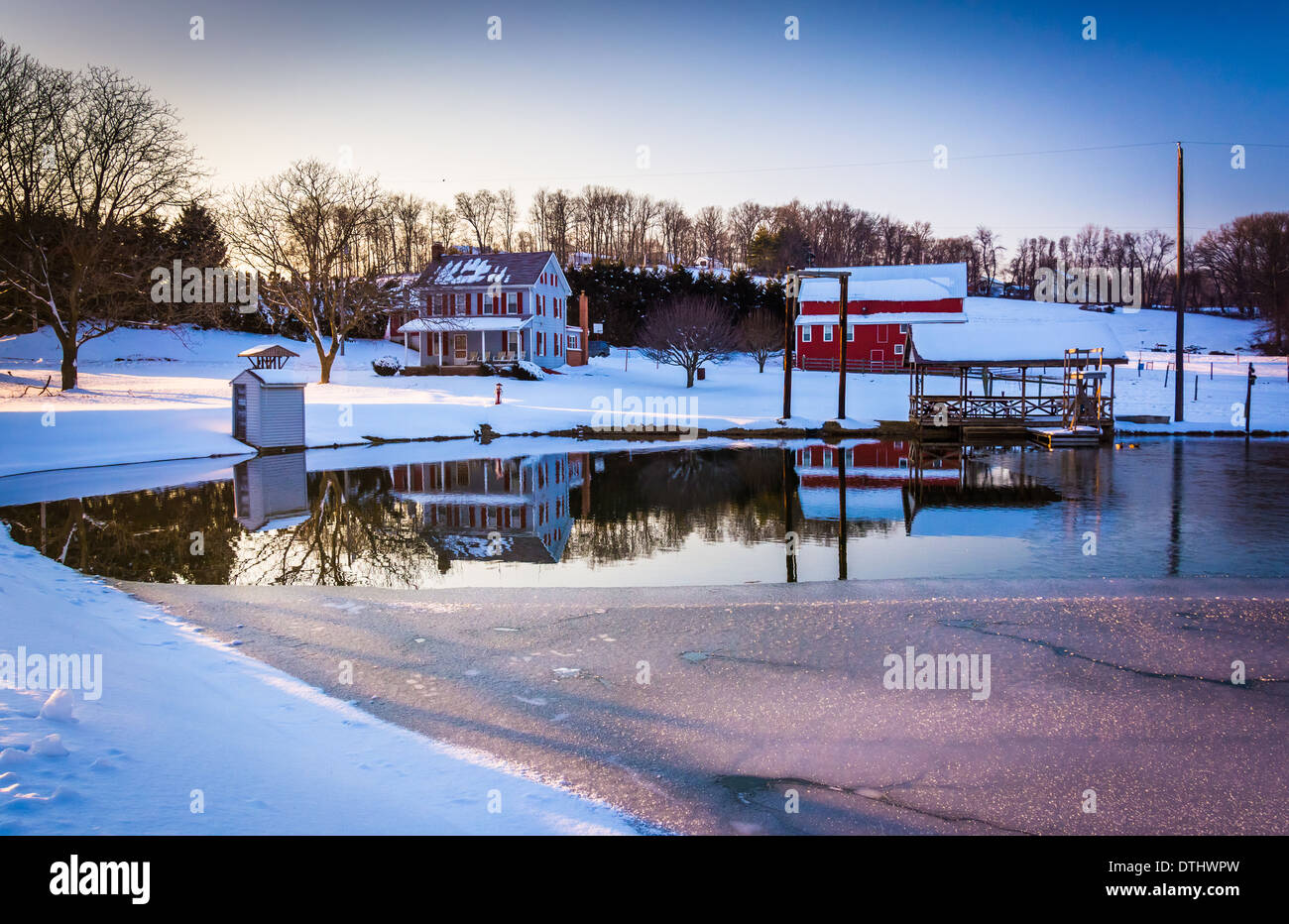 Haus und Scheune reflektiert in einem halb zugefrorenen Teich im ländlichen York County, Pennsylvania. Stockfoto