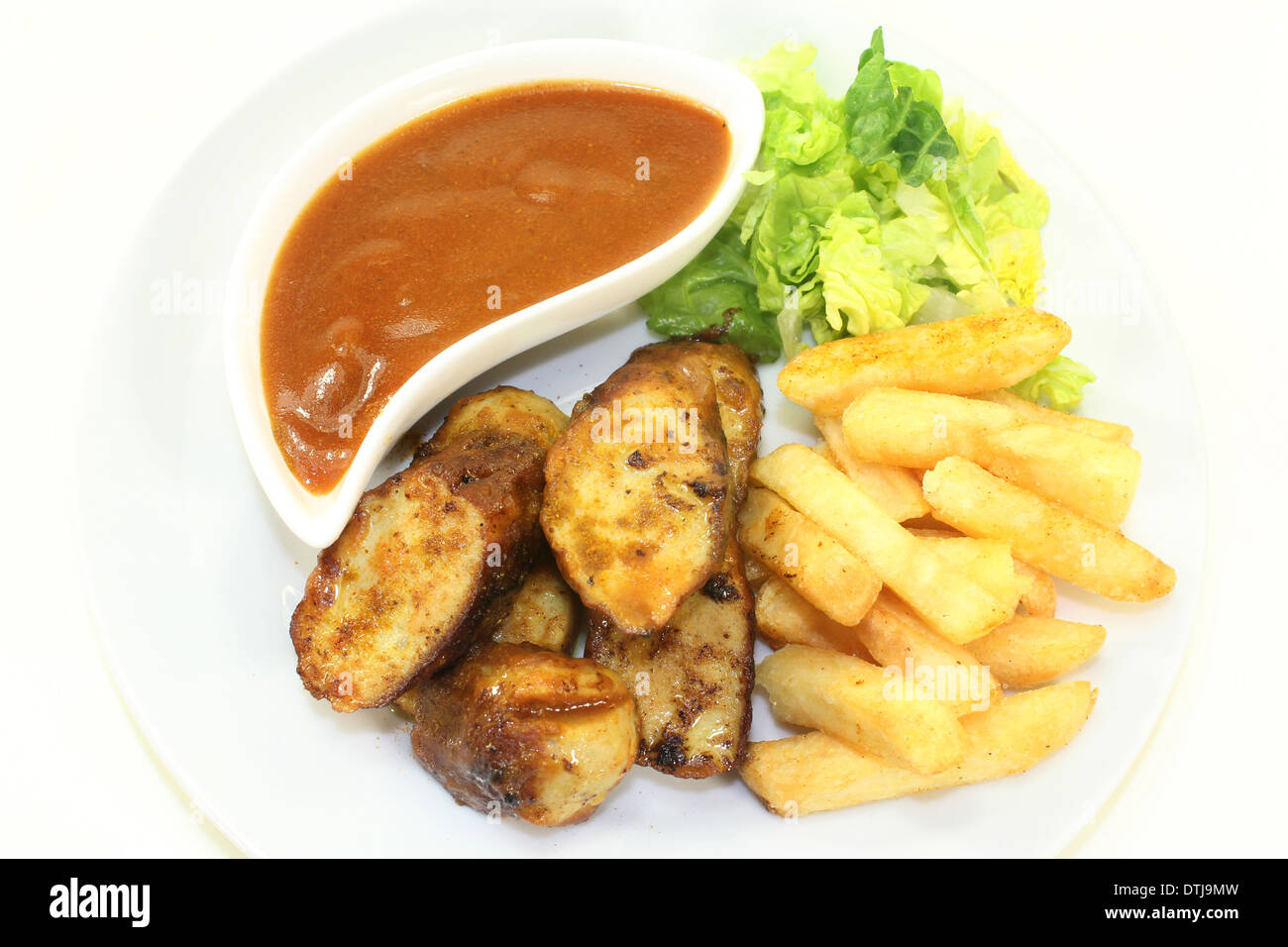 eine Currywurst mit Pommes Frites und Salat Stockfoto