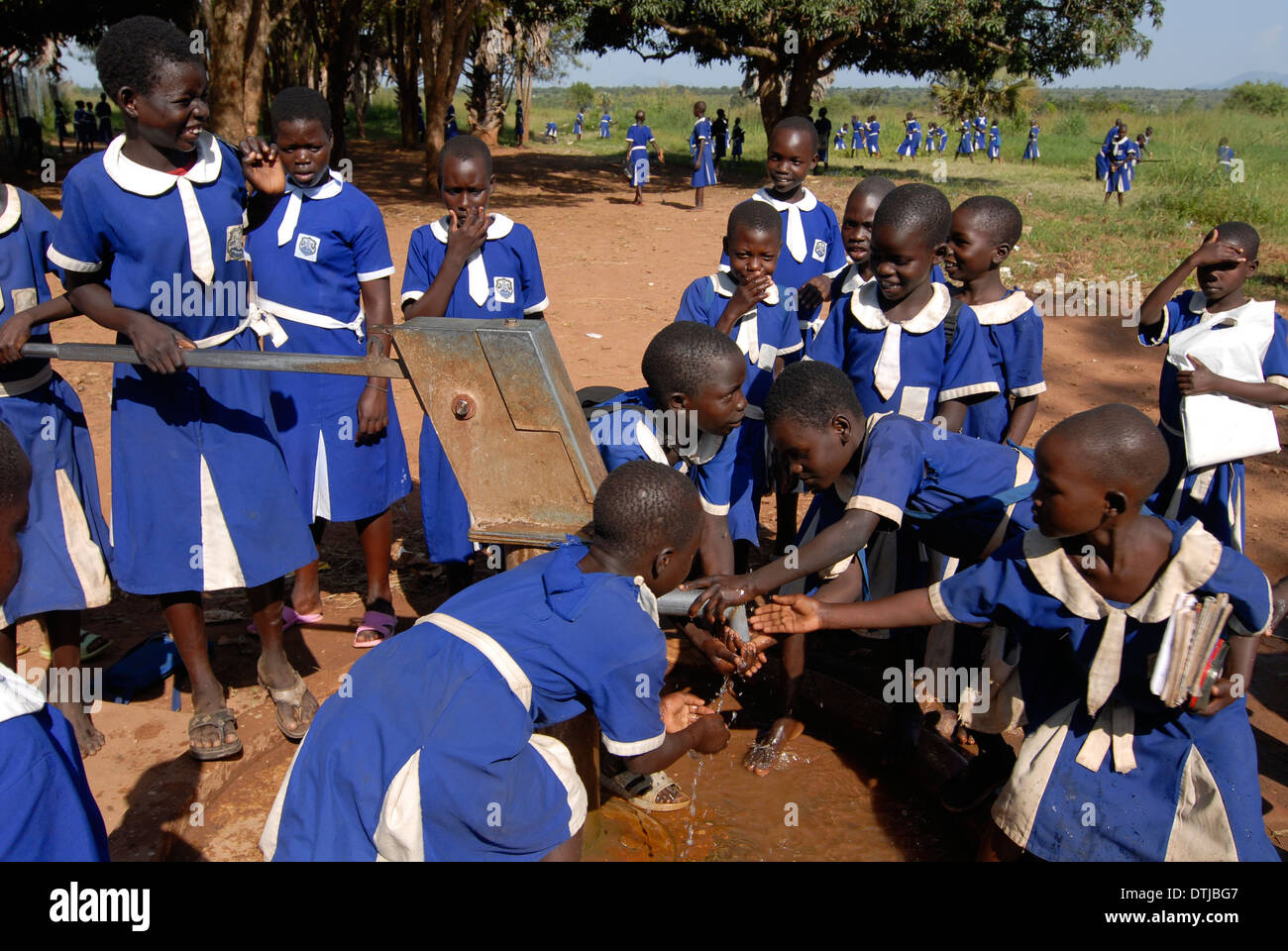 UGANDA Kitgum, Mädchen Schule der katholischen Kirche, Mädchen im blauen Schule einheitliche holen Trinkwasser aus Handpumpe gesetzt Stockfoto
