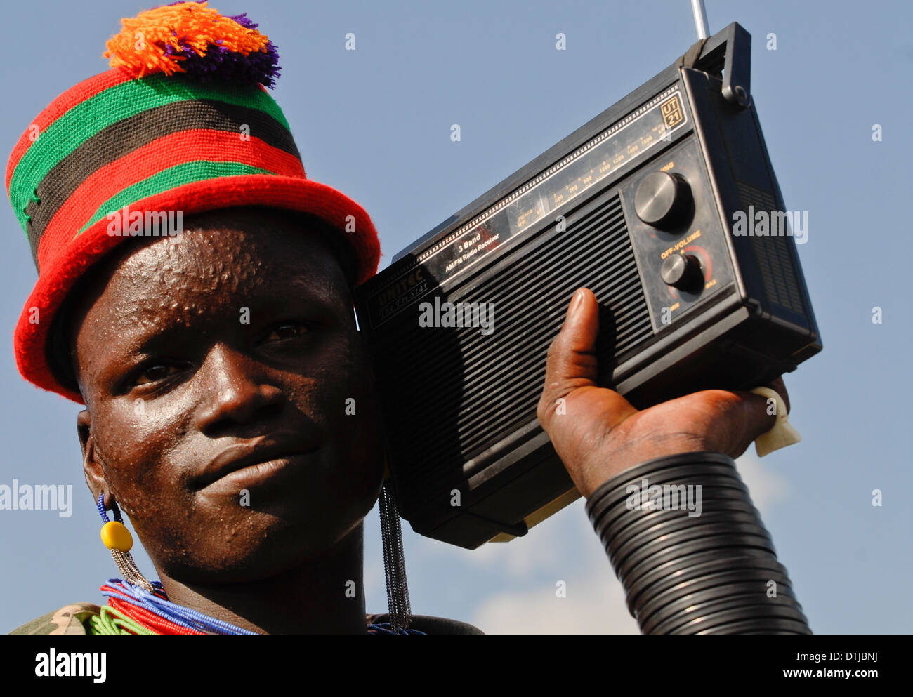 Uganda Karamoja Kotido, Karimojong Menschen, pastorale Stamm, junger Mann mit bunten Hut und Radio Empfänger Stockfoto