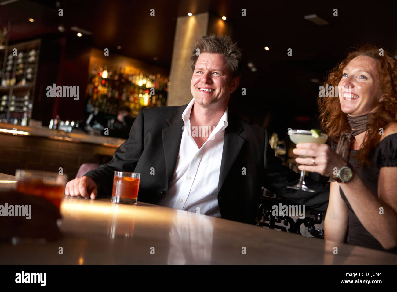 EIN PAAR GENIEßT EINEN DRINK IN EINER WEIN-BAR Stockfoto