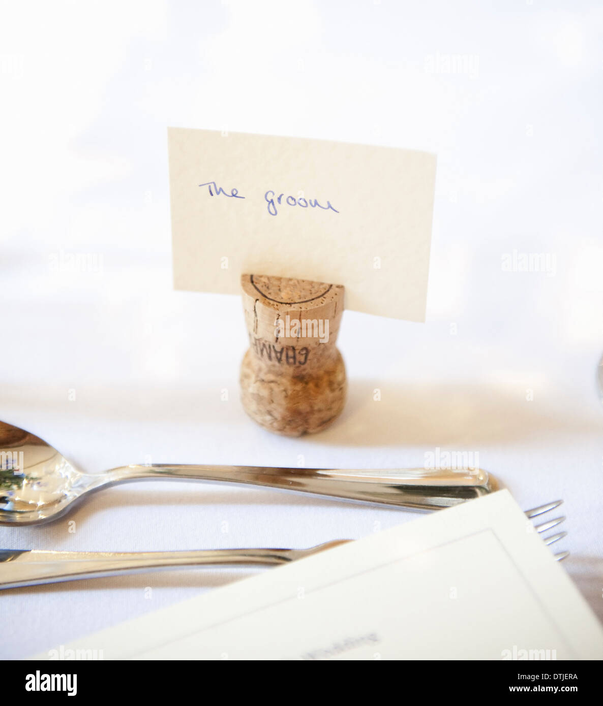 Tisch bei einem Hochzeitsbankett eine Upside-down Kork mit Namensschild für den Bräutigam Silber Gabel und Löffel, England Stockfoto