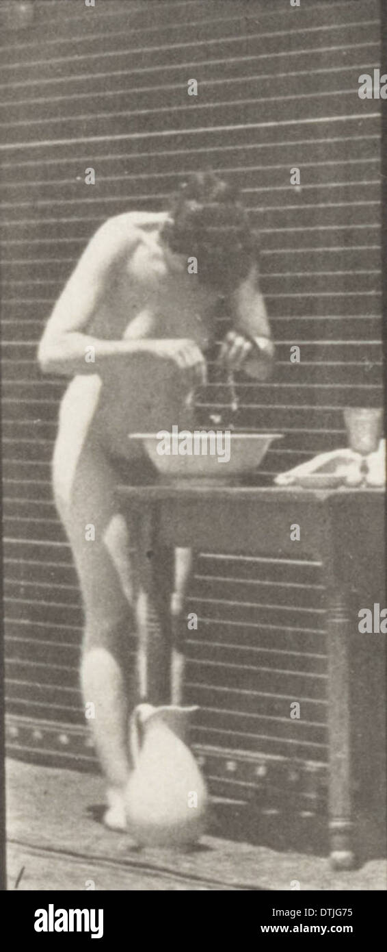 Ein Foto, das eine nackte Frau zeigt, die ihr Gesicht wäscht, aufgenommen in einem einfachen Moment der Körperpflege. Der Schwerpunkt liegt auf der Wirkung der Reinigung in einer natürlichen Umgebung. Stockfoto