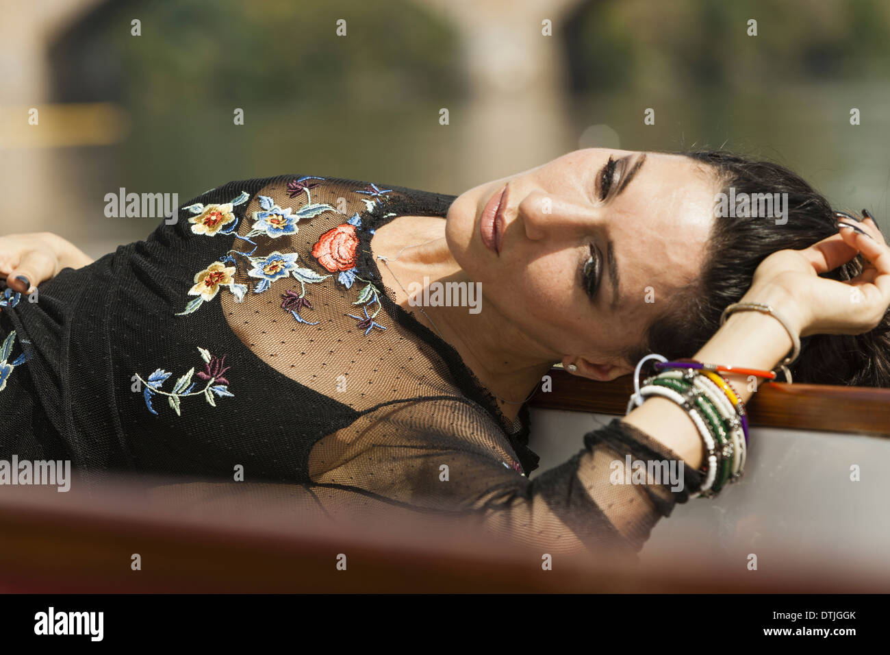 Eine Frau auf dem Rücken liegend, arm tragen ein schwarzes Top mit schiere Ärmel und Stickerei Armbänder auf ihr Pennsylvania USA Stockfoto