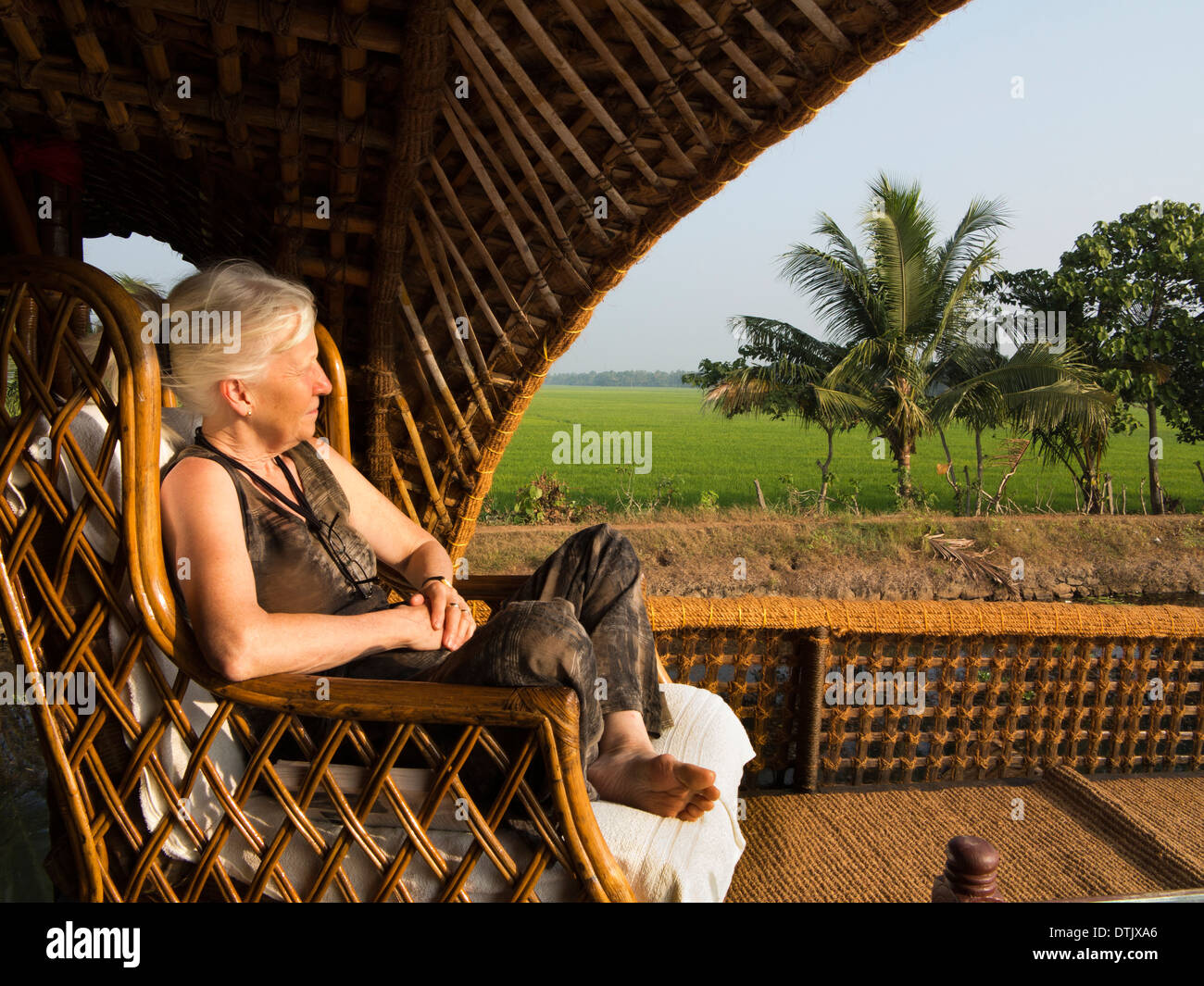 Indien, Kerala, Backwaters, Kettuvallam Bootsfahrt, westliche Frau Entspannung in Cane Stuhl Stockfoto