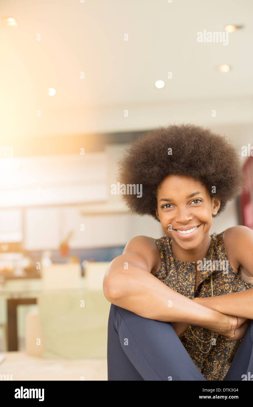 Lächelnde Frau sitzen im Wohnzimmer Stockfoto