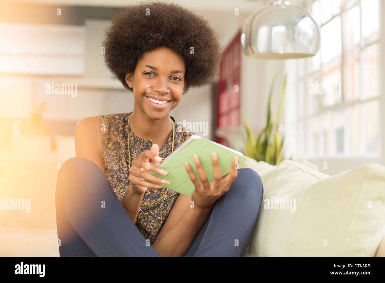 Frau mit digital-Tablette auf sofa Stockfoto