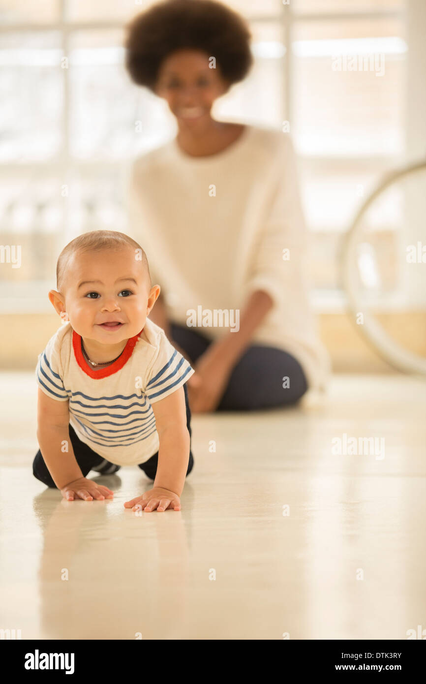 Mutter beobachten Baby Boy kriechen am Boden Stockfoto