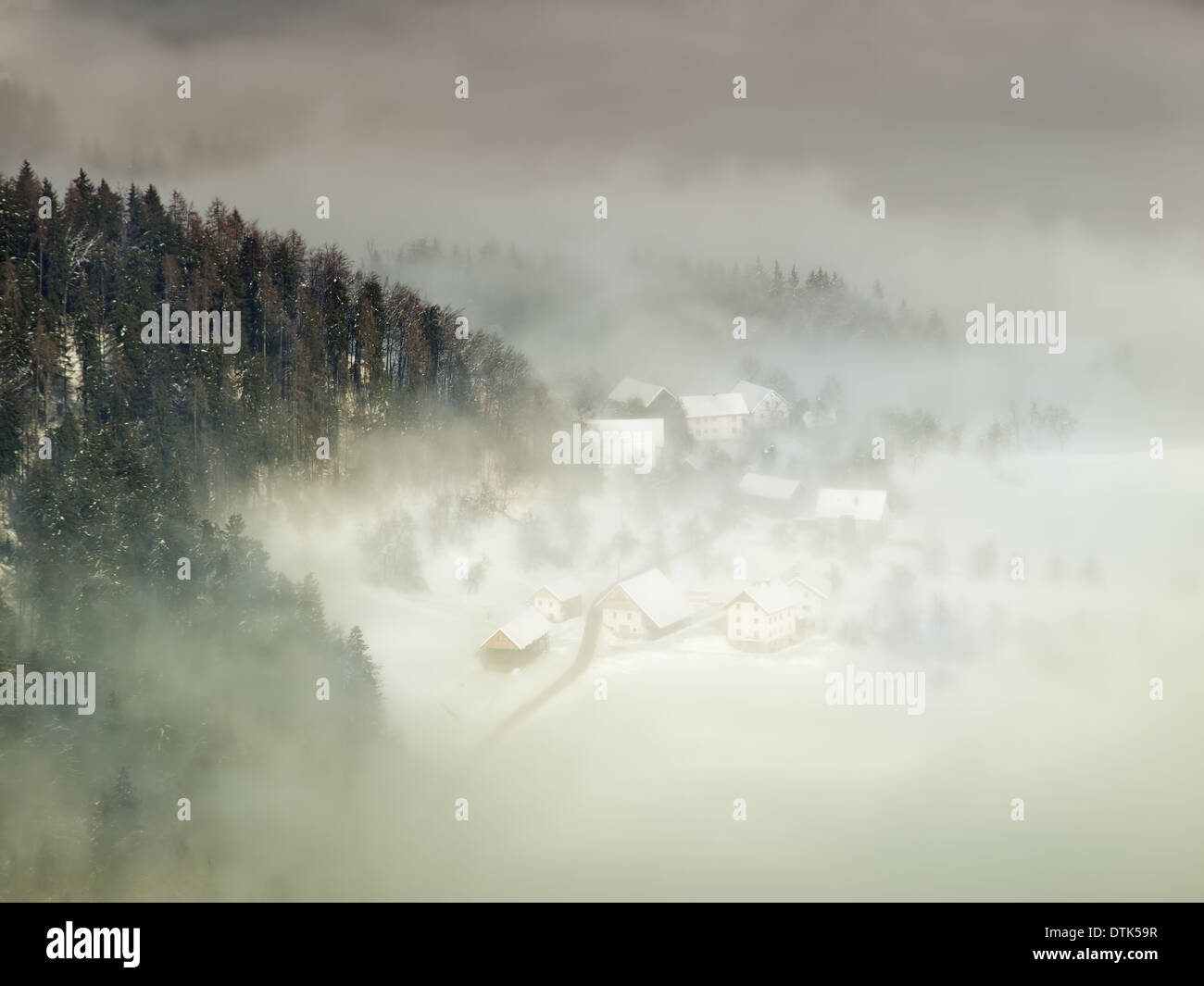 Blick vom Berg auf das Bergdorf im Nebel. Stockfoto