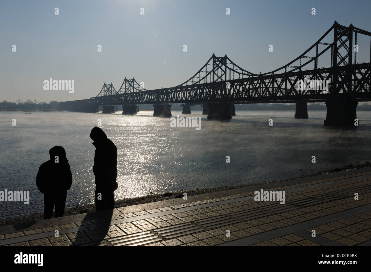 Zwei Männer stehen am Yalu-Fluss in der Nähe der chinesisch-koreanische Freundschaftsbrücke.  Provinz Liaoning. Dandong, China. Stockfoto