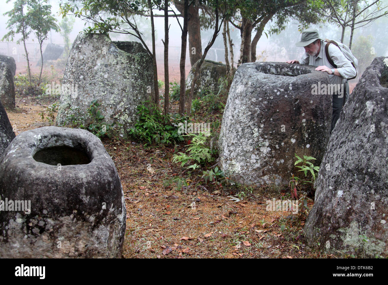 Ebene des Jars Site 3 in ländlichen Laos, wo die megalithischen Monumente in den frühen Morgennebel untersucht werden Stockfoto