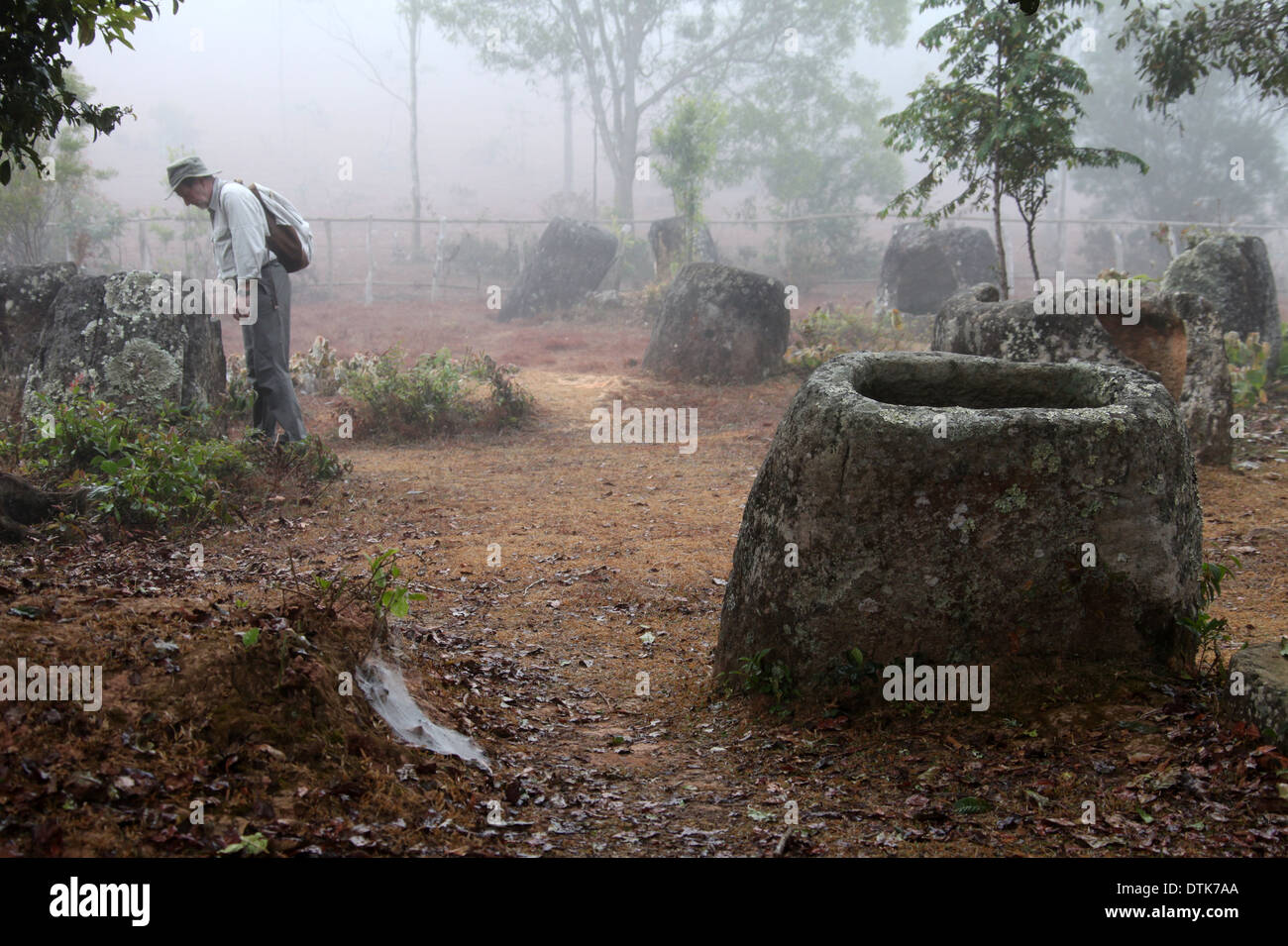 Ebene des Jars Site 3 in ländlichen Laos, wo die megalithischen Monumente in den frühen Morgennebel untersucht werden Stockfoto