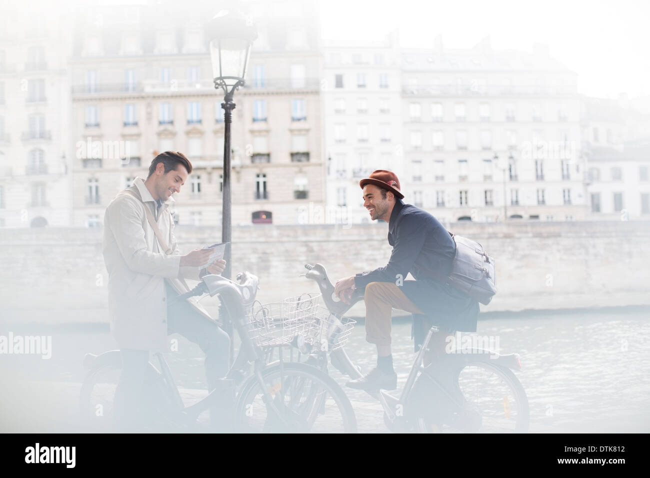 Geschäftsleute sprechen auf Fahrrädern entlang Seine, Paris, Frankreich Stockfoto