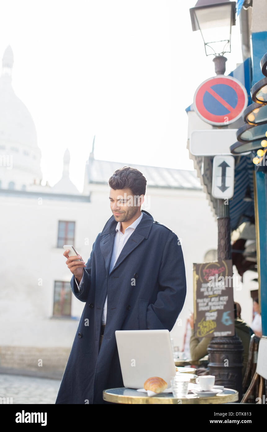 Geschäftsmann mit Handy im Straßencafé Stockfoto