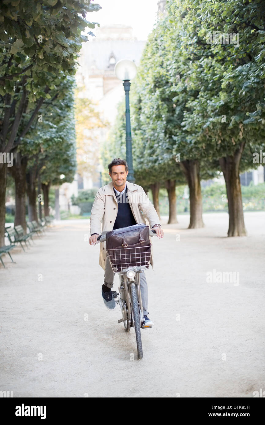 Geschäftsmann Reiten Fahrrad im Park, Paris, Frankreich Stockfoto