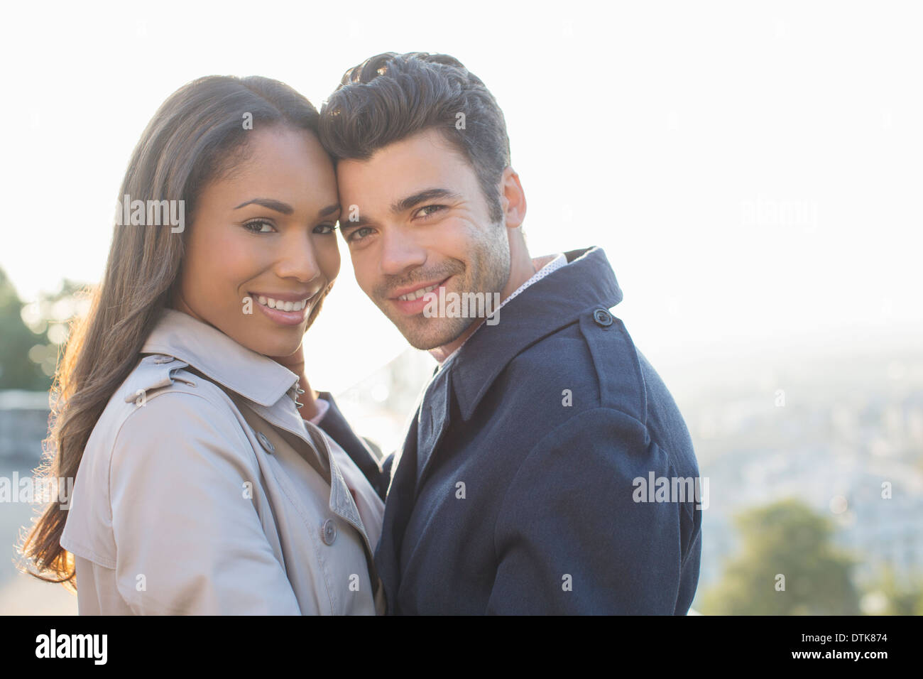 Paar in Trenchcoats umarmt Stockfoto