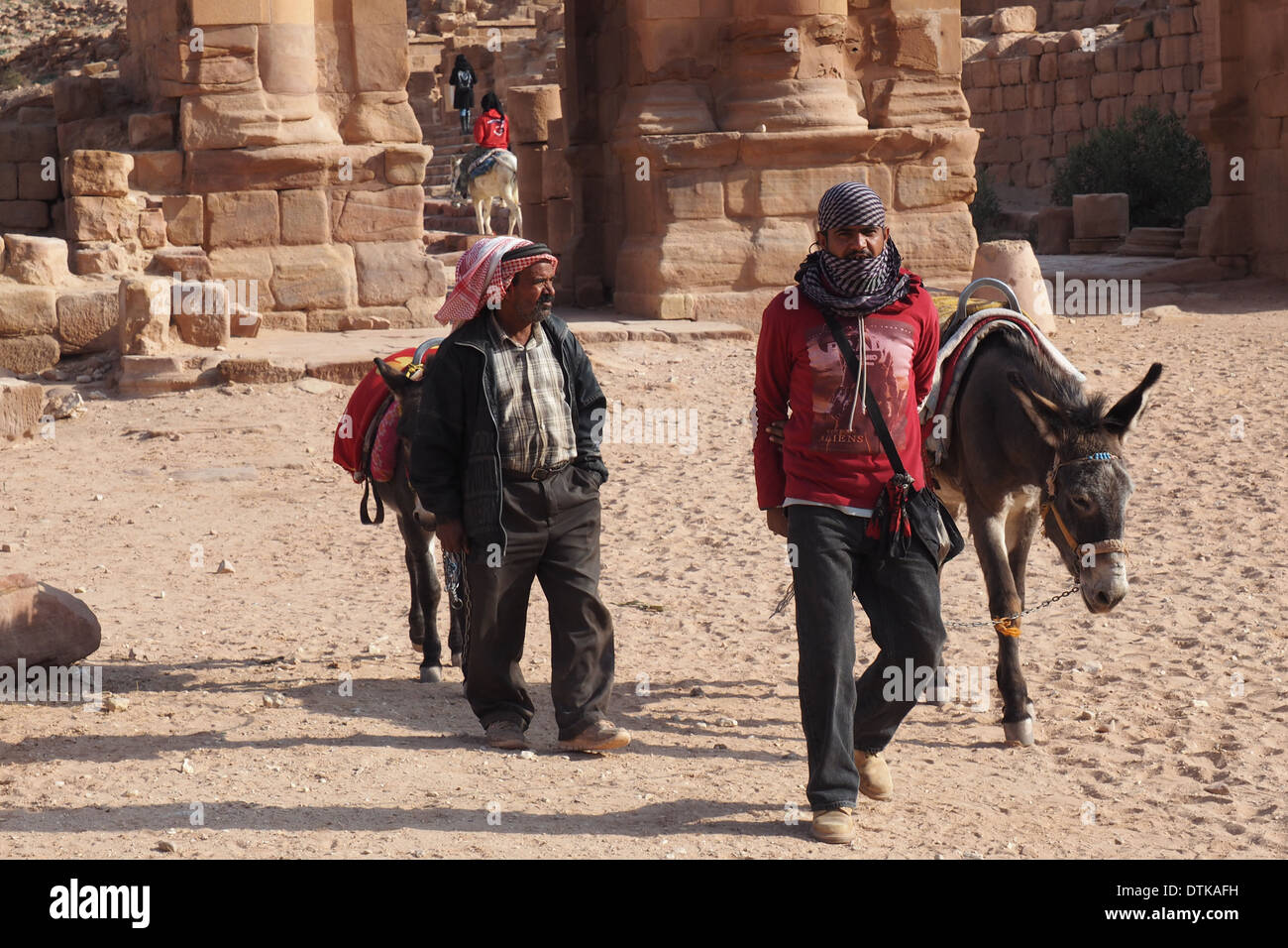 zwei Beduinen Männer gehen ihren Eseln vor Orgelwettbewerb Tor Petra Jordan zum UNESCO-Weltkulturerbe Stockfoto