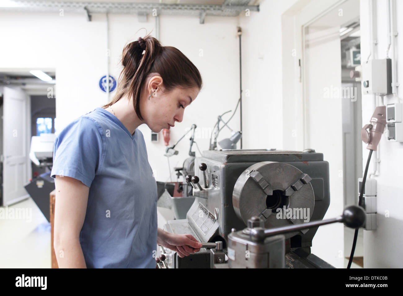 junge Frau in einem Handwerk Mechaniker Raum arbeiten Stockfoto