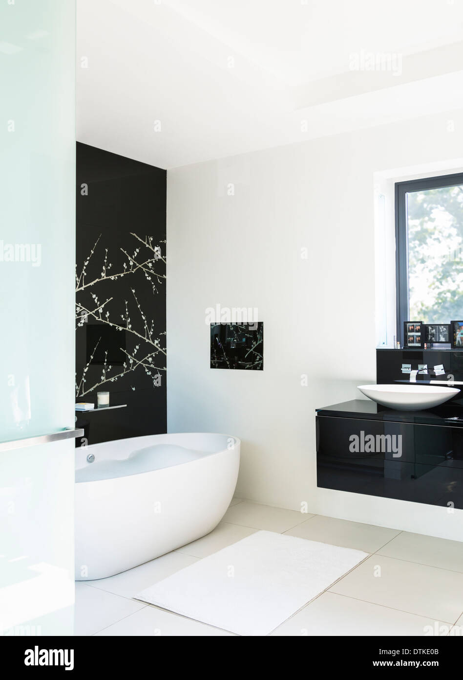 Wandkunst und großzügige Badewanne im modernen Badezimmer Stockfoto